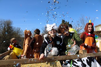 Des enfants sur le char jettent des confettis